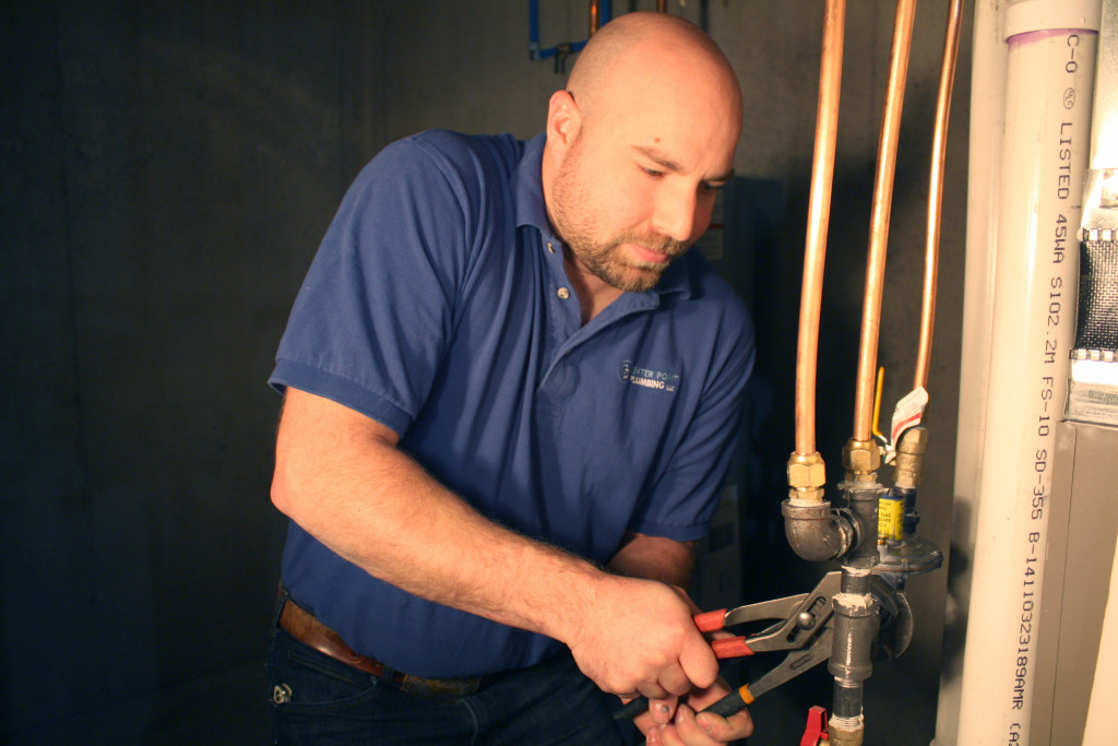 A plumber tightening gas pipe fittings.