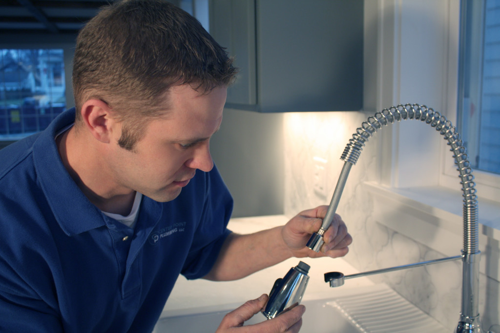 A plumber assembling a kitchen faucet